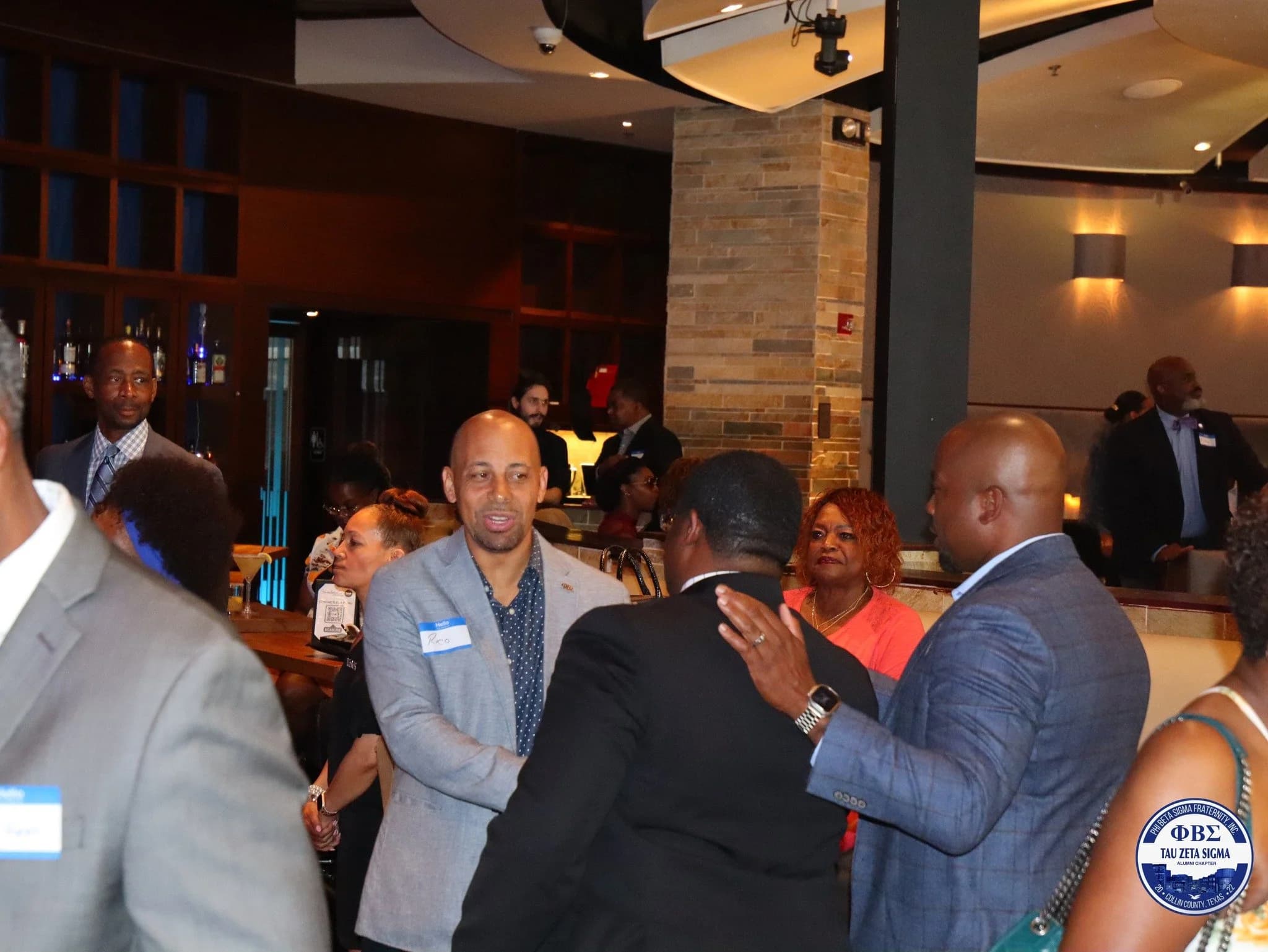 Brothers greeting guests at a chapter networking event