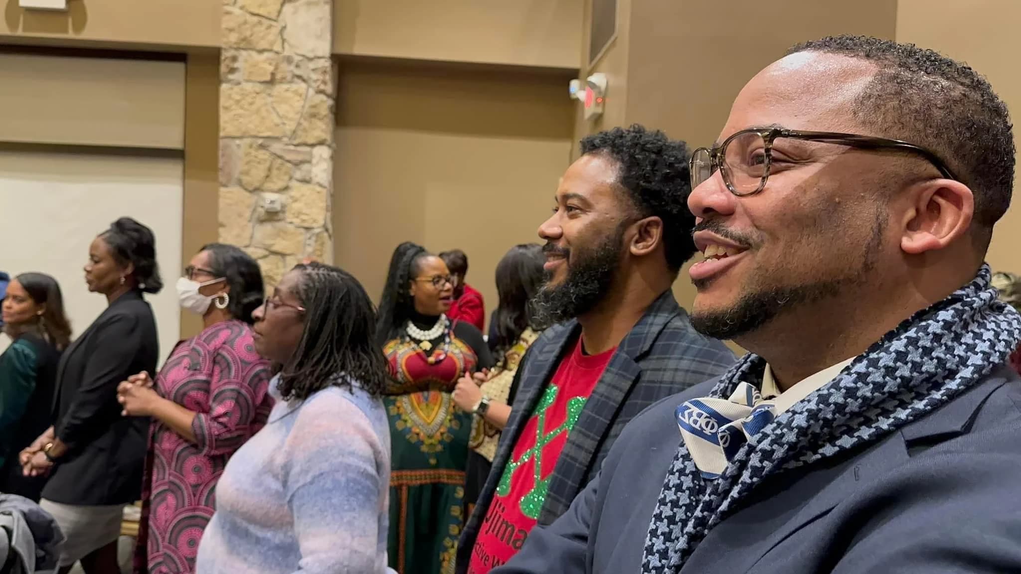 Brothers and community members singing together at a holiday gathering